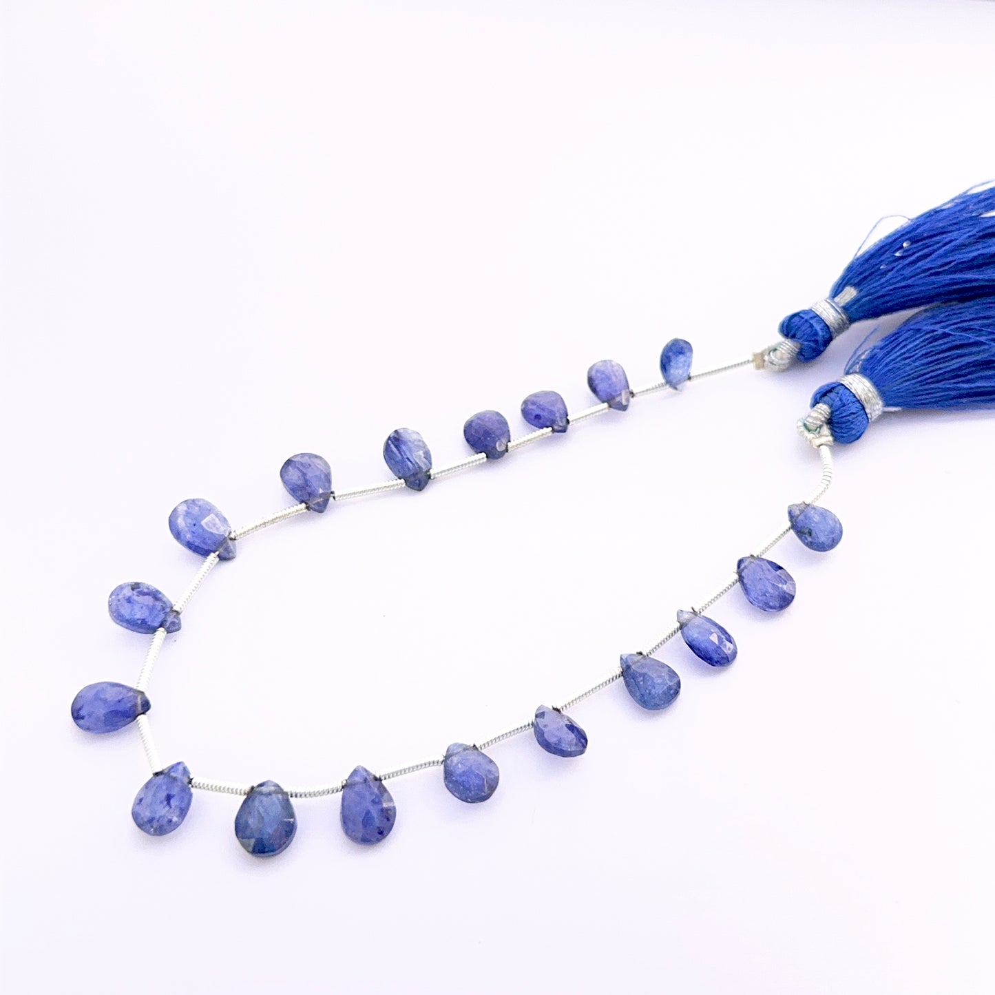 Close‑up of Blue Sapphire pear faceted almond 7–9mm beads highlighting crisp facets and intense sapphire colour.
