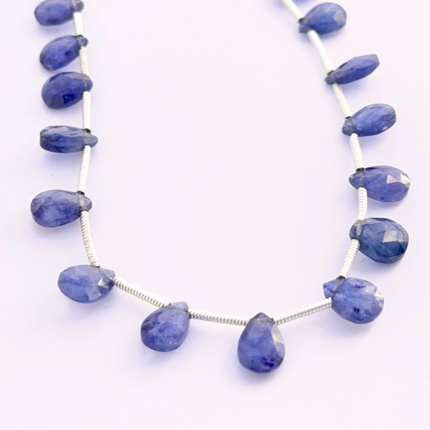 Set of 18 Blue Sapphire pear faceted almond beads 7–9mm totalling 33 carats, ideal for bespoke jewellery settings.
