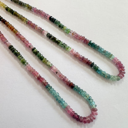 Close-up of 4-4.5mm Watermelon Tourmaline gemstones arranged in a neat strand, highlighting their precision cut and clarity.