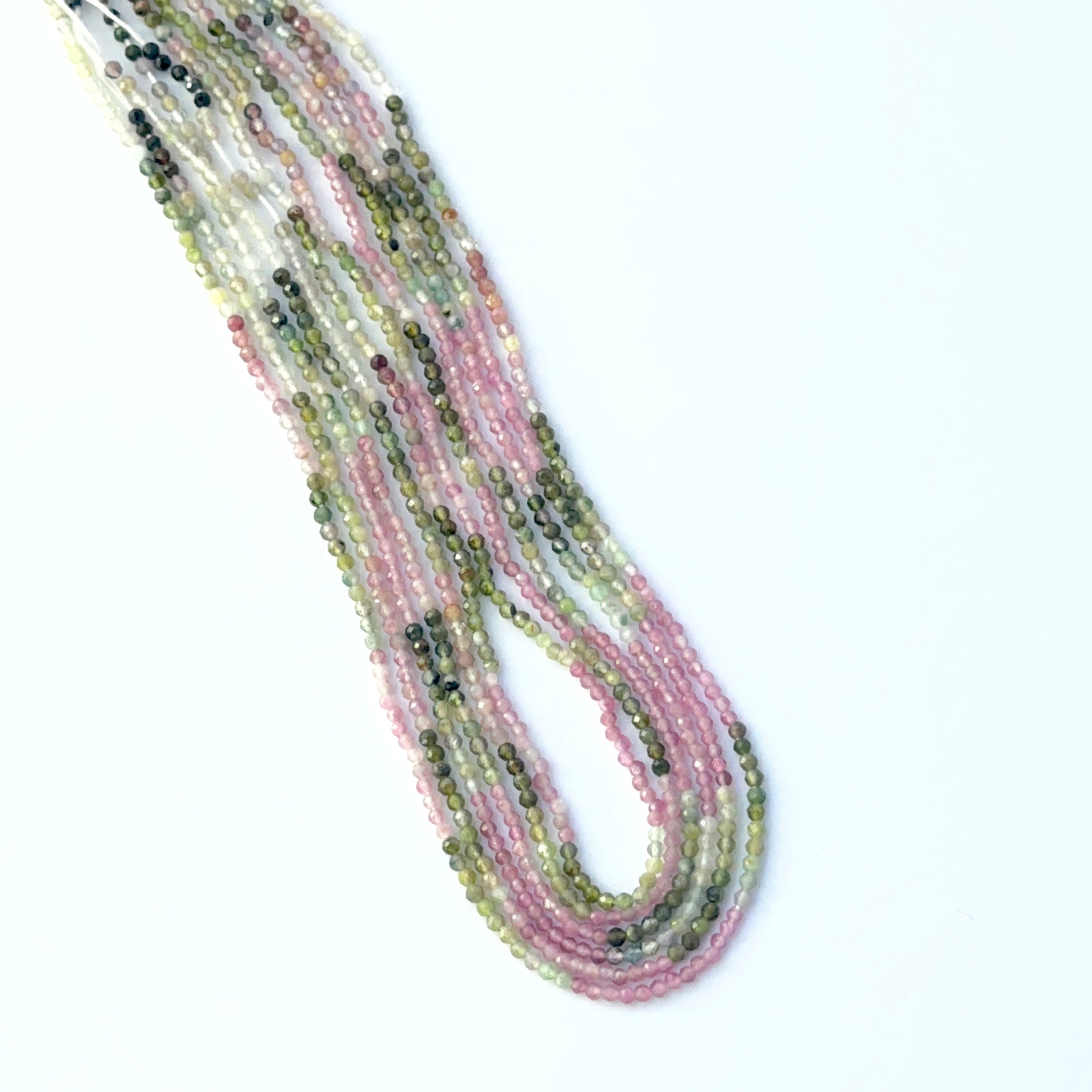 Stone beads made from Watermelon Tourmaline showing vibrant bi‑colour tones and neatly cut rondelle shapes.
