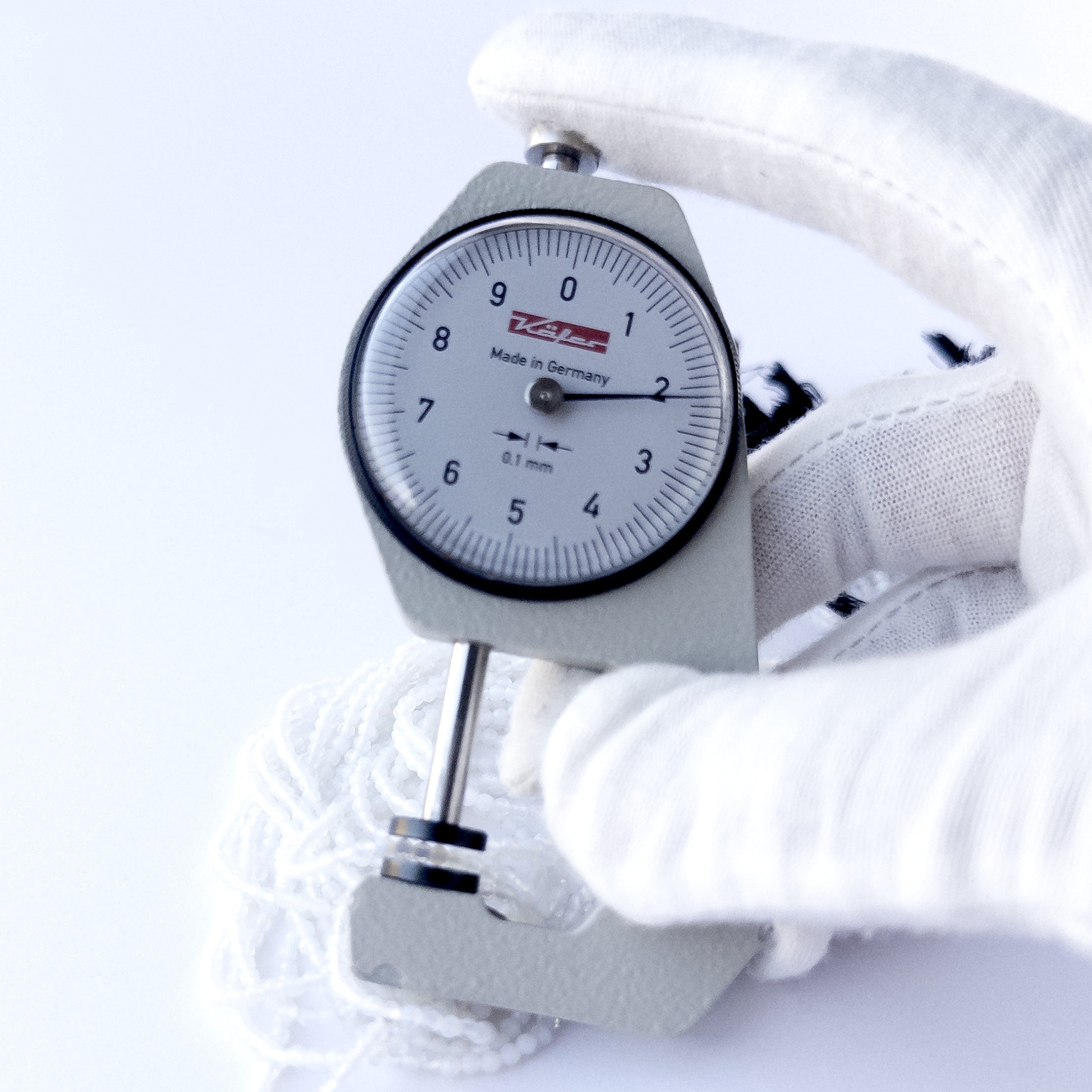 A dial gauge measures the White Chalcedony faceted rondelle 2.1mm gemstone.