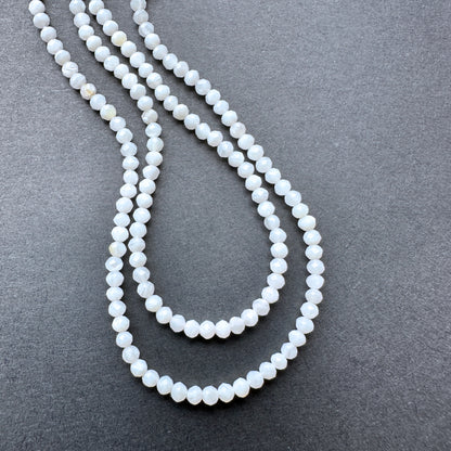 White Opal faceted rondelle beads with soft milky tones arranged on a 32cm strand for jewellery making.