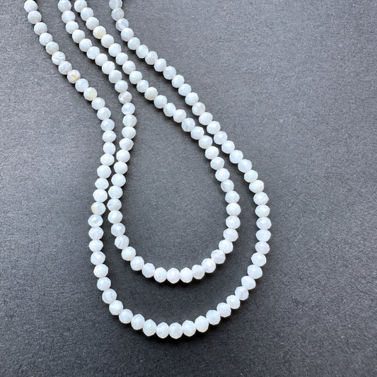 White Opal faceted rondelle beads with soft milky tones arranged on a 32cm strand for jewellery making.