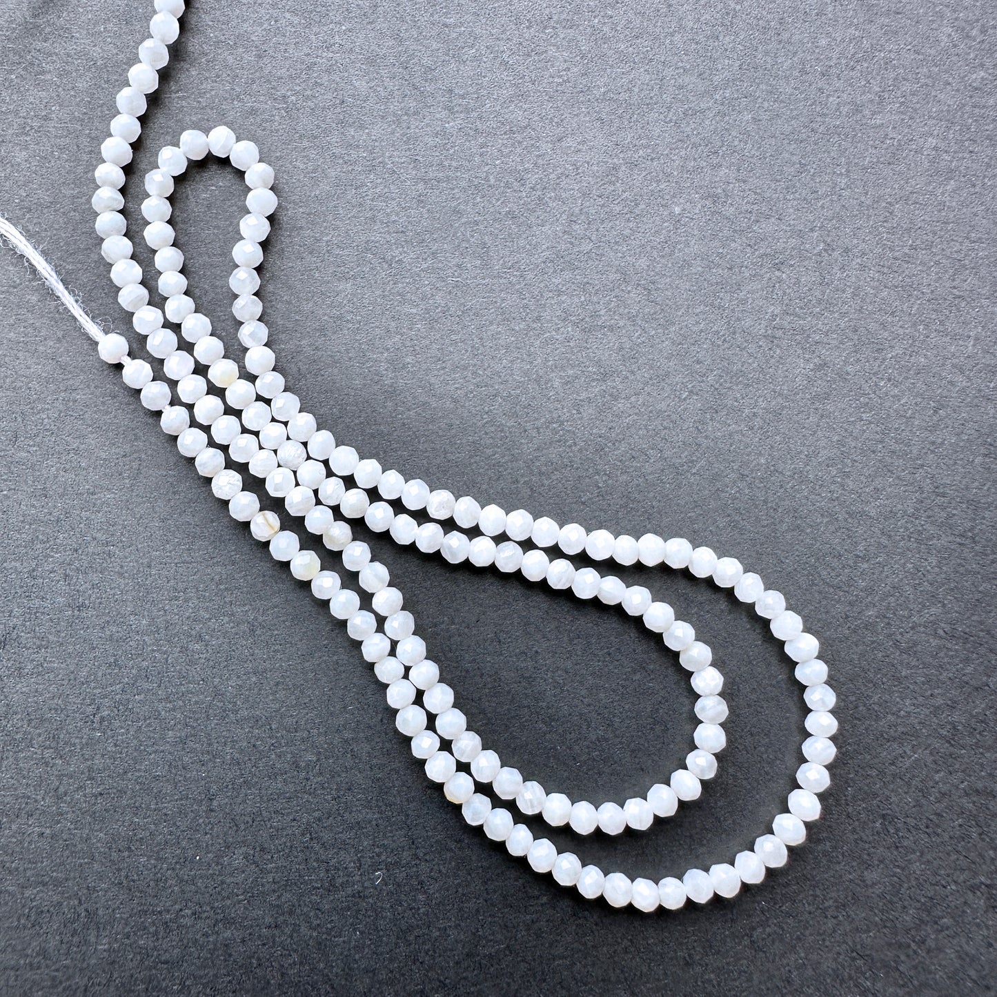 A dial gauge measures the White Opal faceted rondelle 2.4mm gemstone.