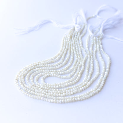 Handmade jewellery components featuring natural White Opal faceted rondelles, highlighting their glow, colour, and refined finish.