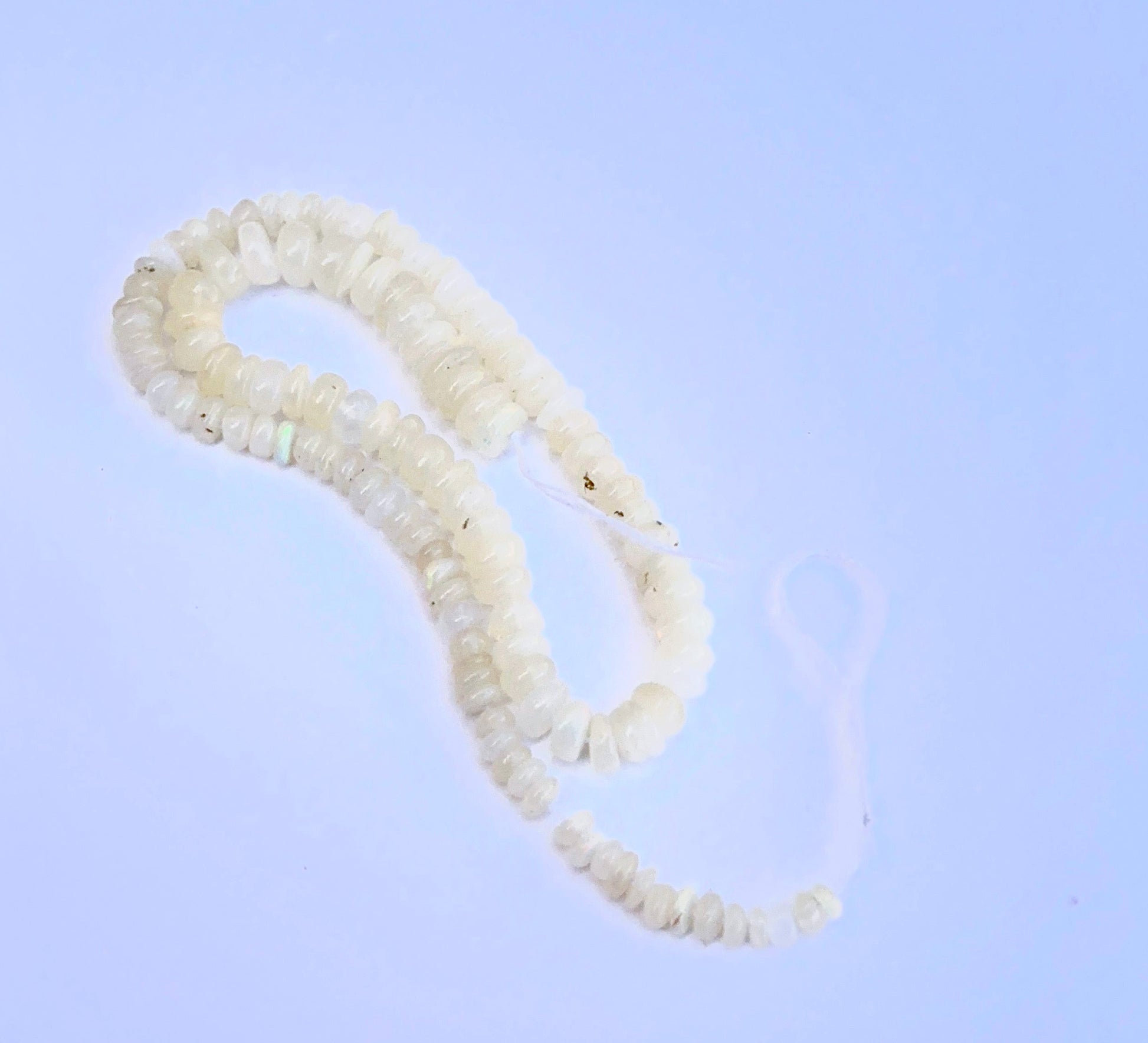 Stone beads arranged on a 20cm strand showcasing polished finish and gentle shine.