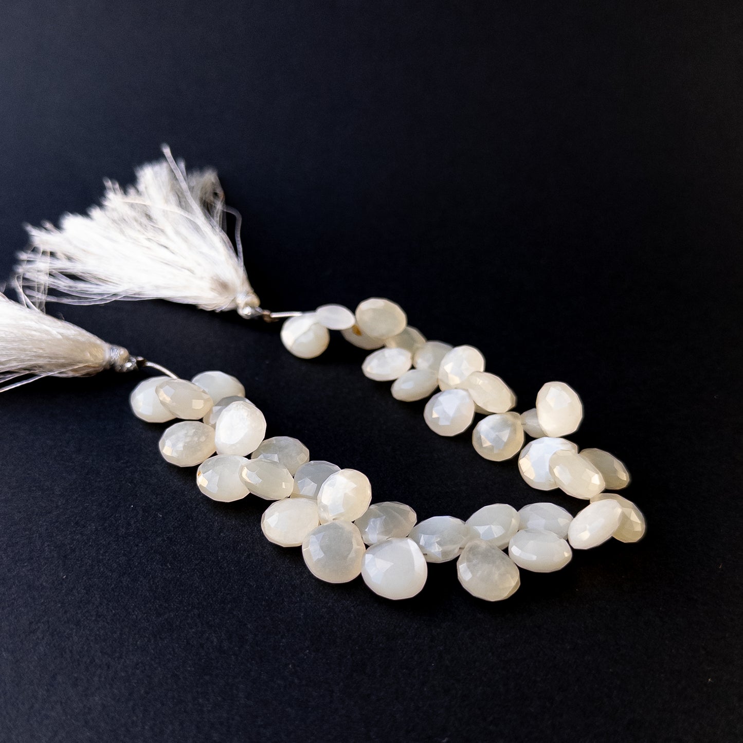 High‑quality moonstone briolette gemstone beads with bright shine and natural adularescence on a short strand.