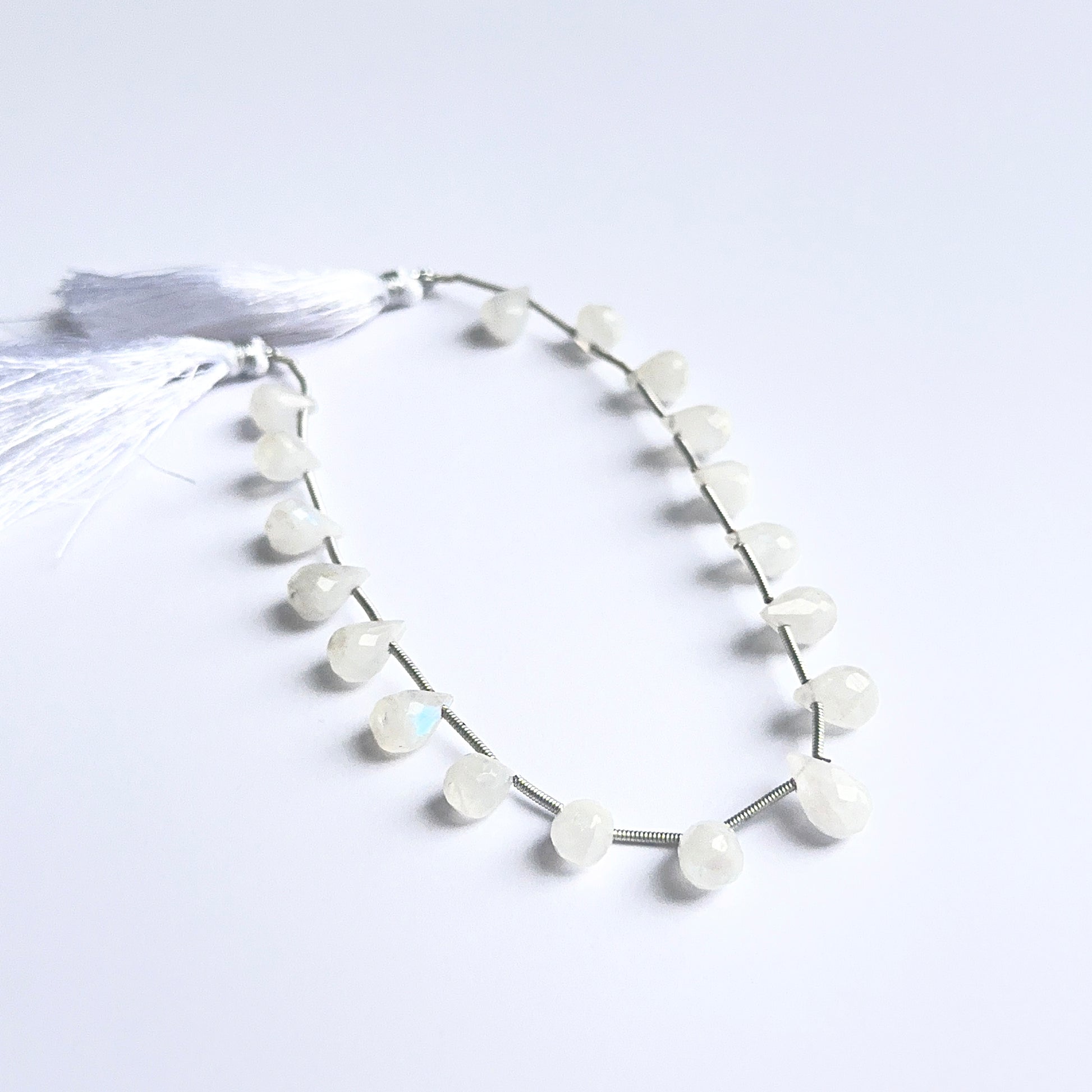 White rainbow moonstone faceted briolettes showing natural shimmer and fine cut for handmade jewellery.