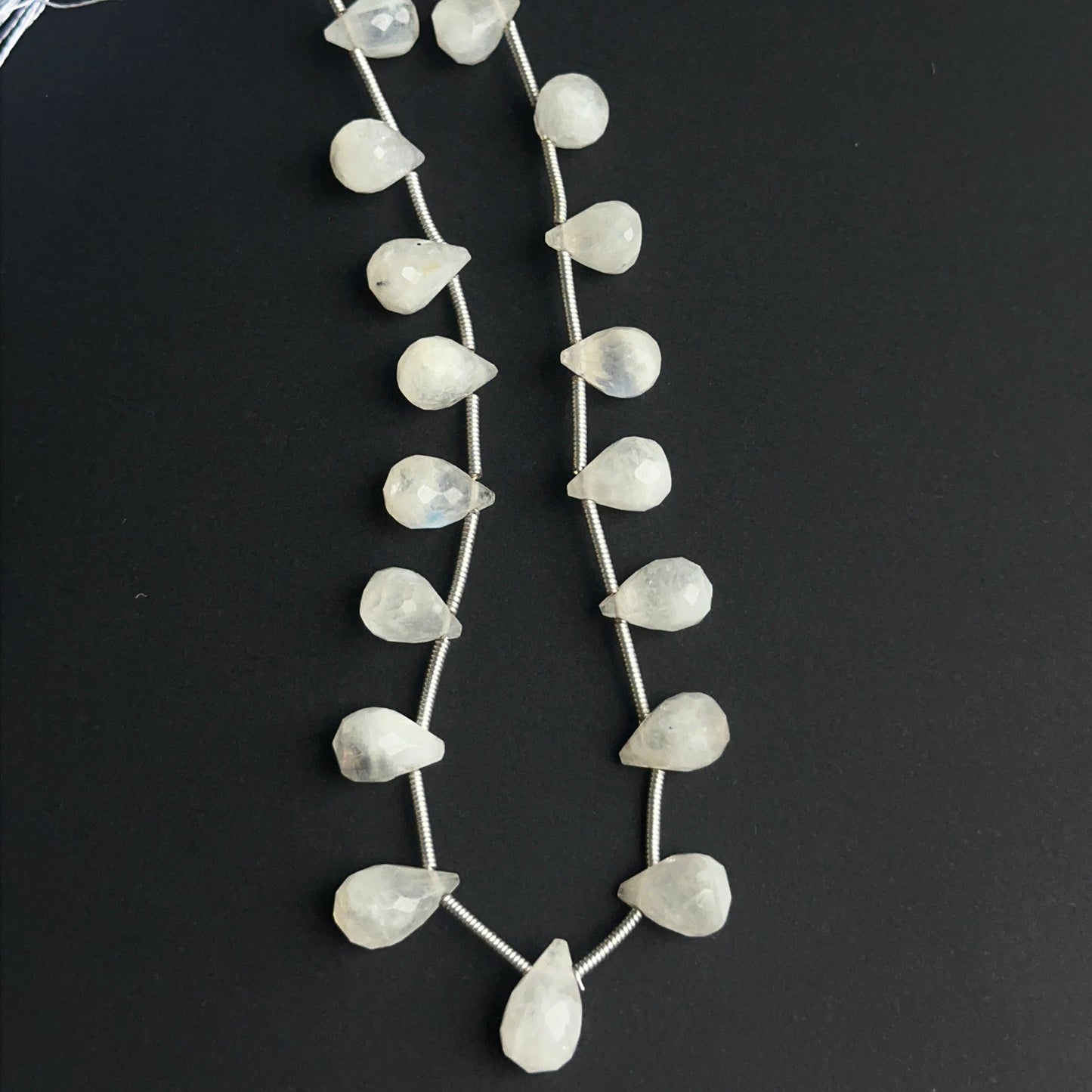 Faceted rainbow moonstone beads displayed with bright reflective surfaces ideal for jewellery making.