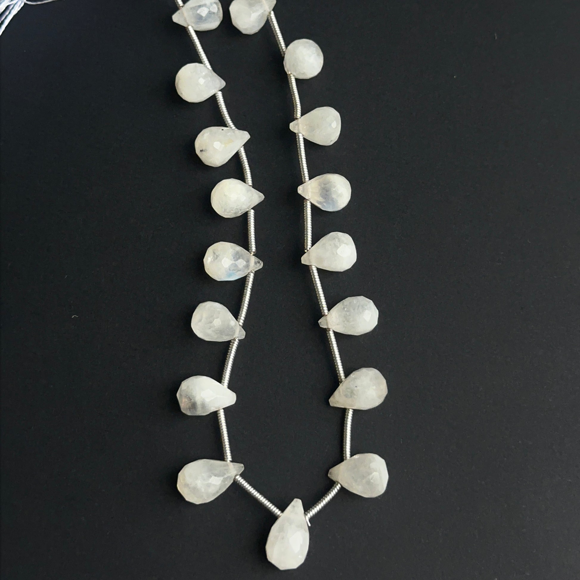 Faceted rainbow moonstone beads displayed with bright reflective surfaces ideal for jewellery making.