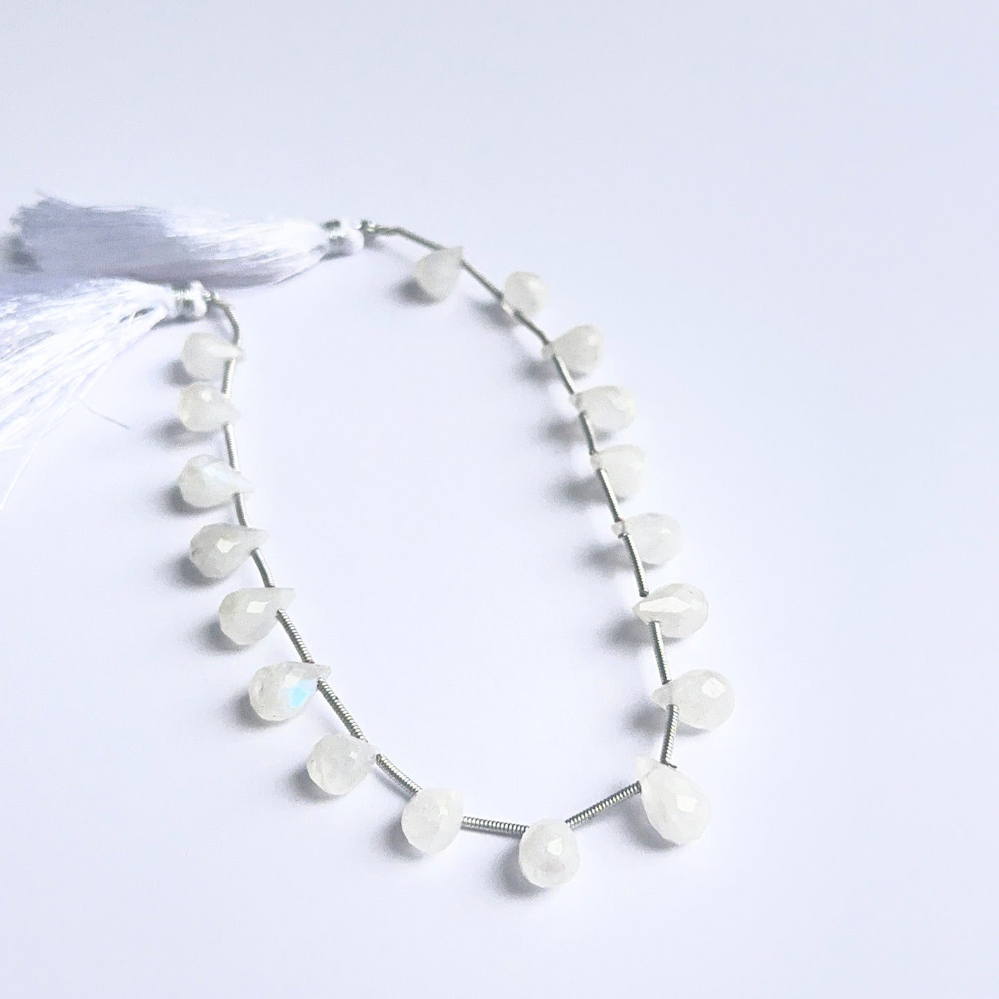 Moonstone faceted briolettes arranged neatly to showcase natural gemstone quality and soft rainbow flash.