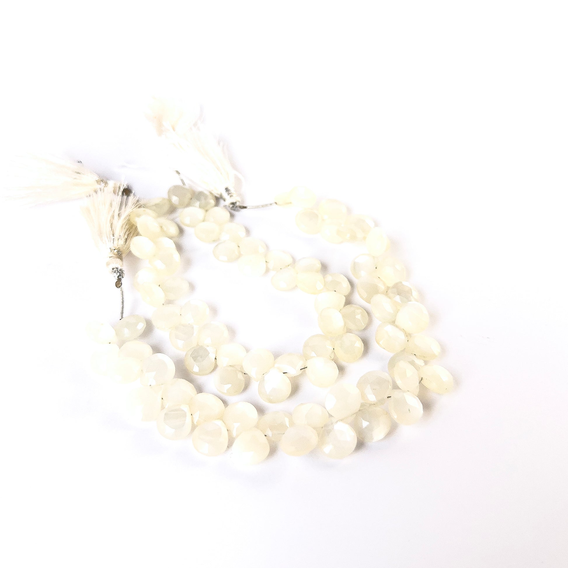 White Rainbow Moonstone faceted briolette beads with glowing sheen arranged on a strand for handmade jewellery components.