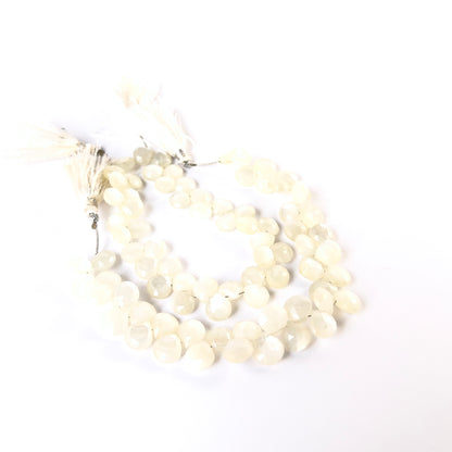 White Rainbow Moonstone faceted briolette beads with glowing sheen arranged on a strand for handmade jewellery components.