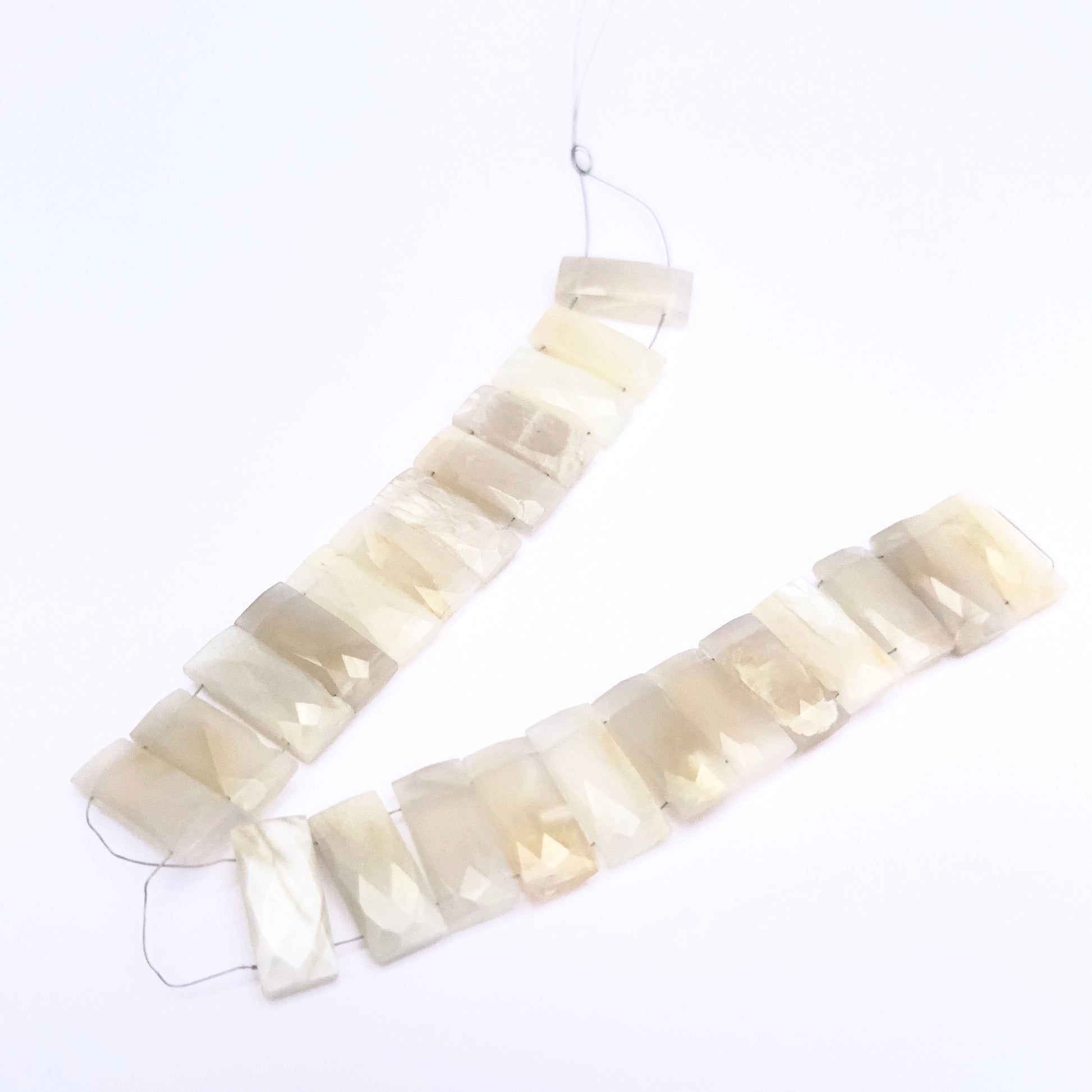 Close-up of White Rainbow Moonstone gemstone beads showing faceted cut and clarity.