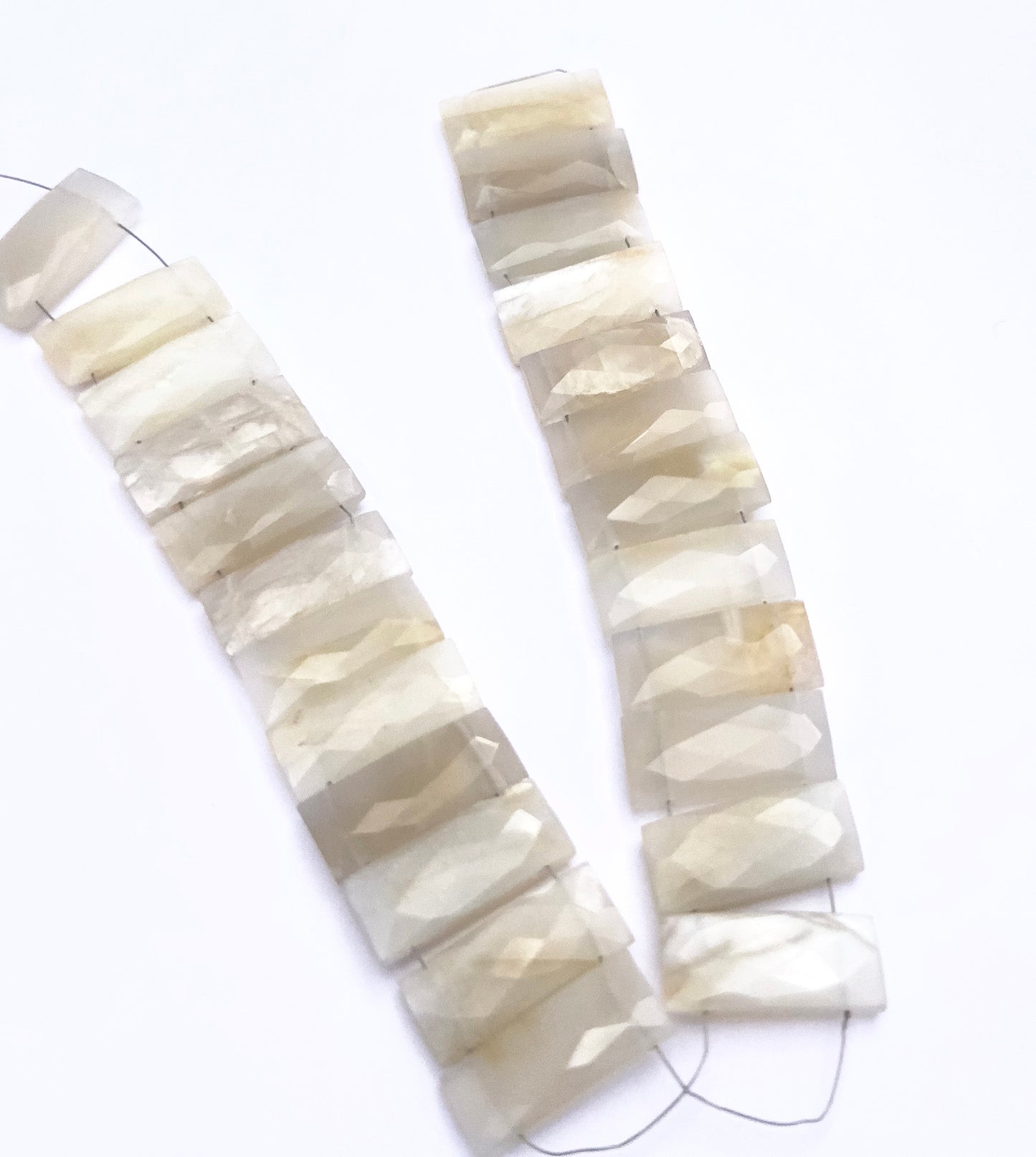 White Rainbow Moonstone beads for DIY jewellery displayed with soft lighting and texture.