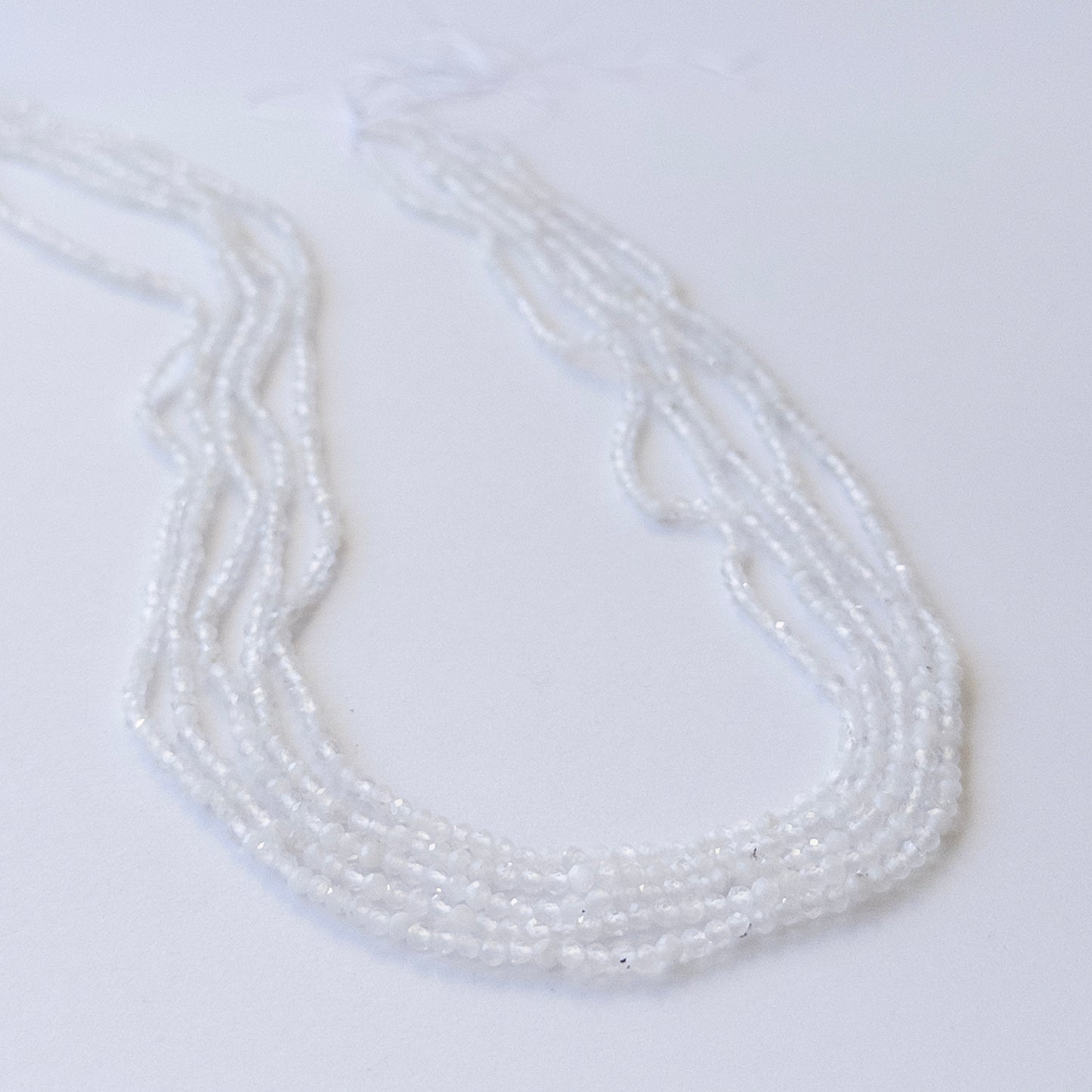 Delicate Rainbow Moonstone micro‑faceted beads showcasing shimmer and clarity for DIY gemstone designs.