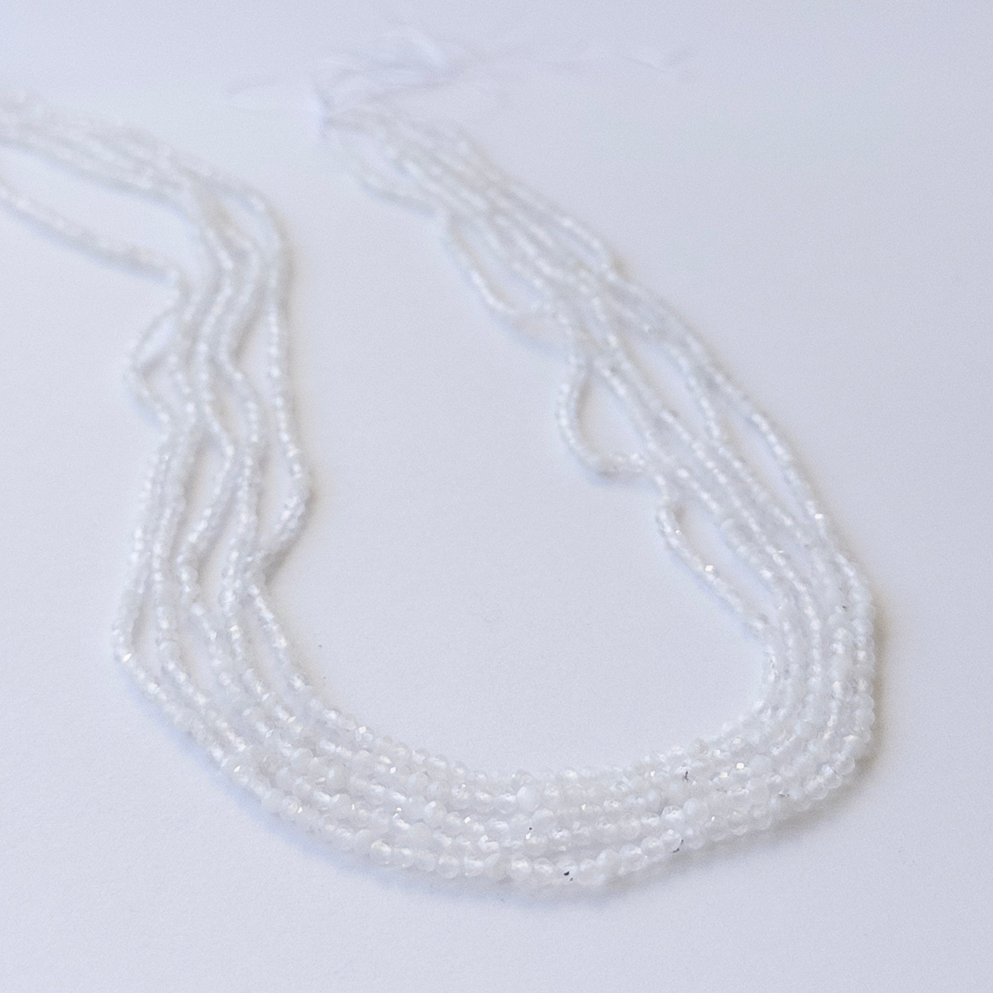 Delicate Rainbow Moonstone micro‑faceted beads showcasing shimmer and clarity for DIY gemstone designs.