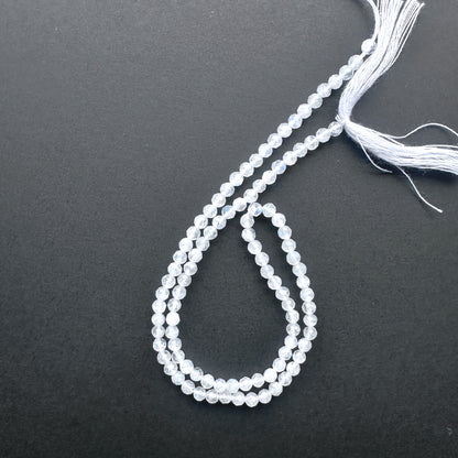 32cm strand of White Rainbow Moonstone gemstone rondelles arranged for DIY jewellery inspiration.