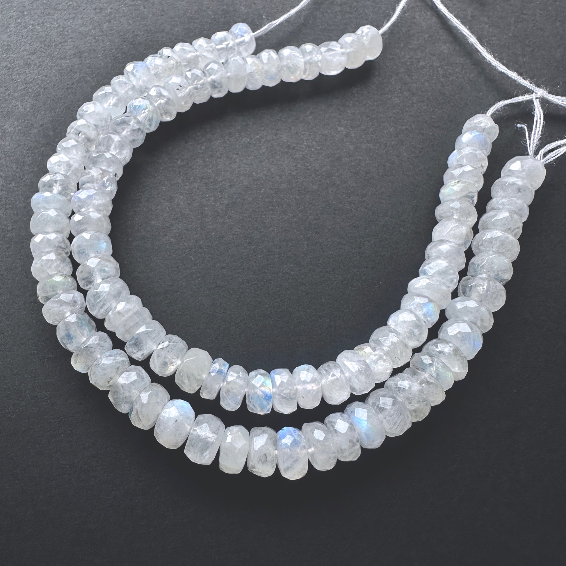 Close-up of White Rainbow Moonstone beads showcasing their iridescent glow and precision faceting.