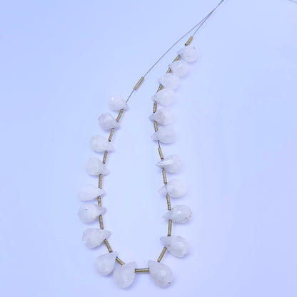 White Rainbow Moonstone faceted teardrop beads arranged in a neat row on a neutral background.