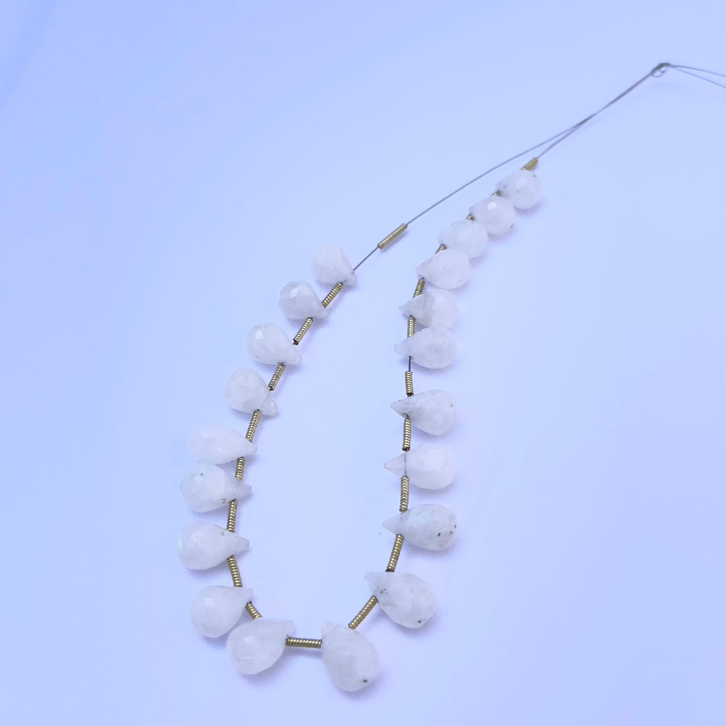 Faceted teardrop Moonstone beads displayed with soft lighting to highlight their cut and polish.