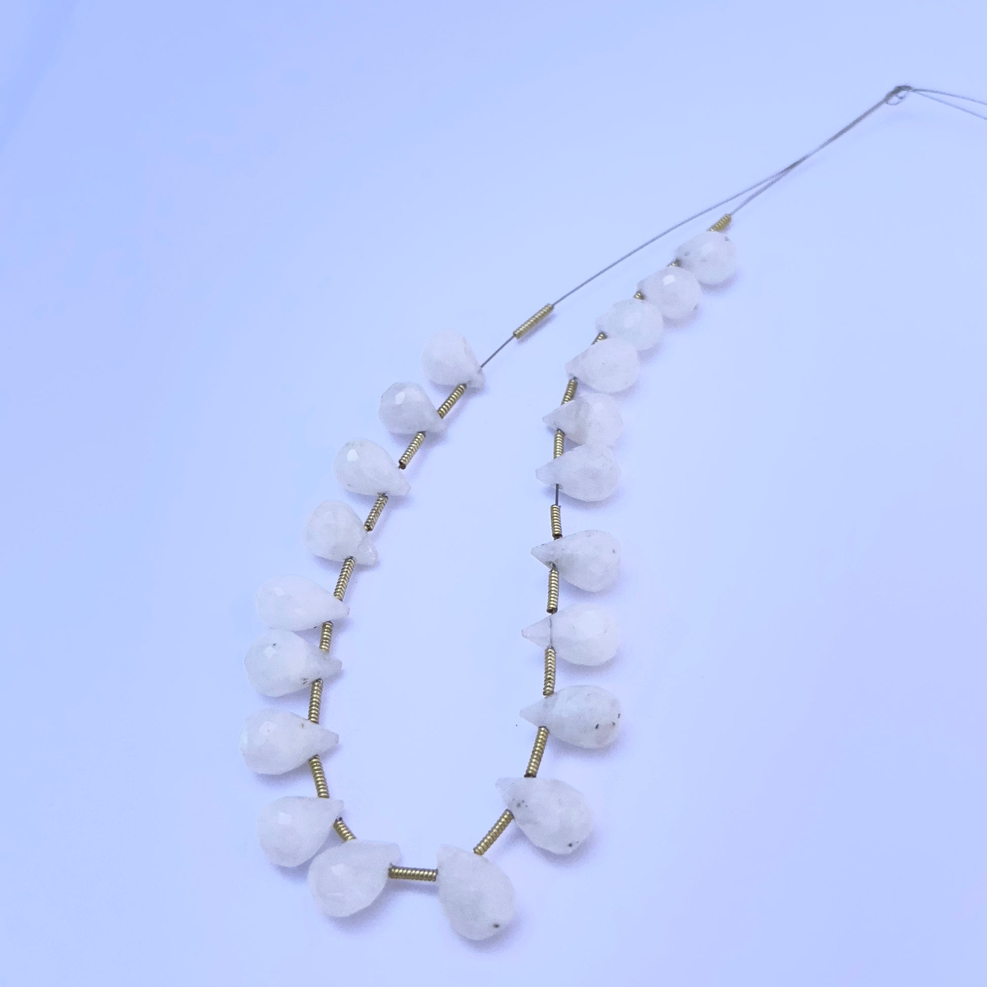 Faceted teardrop Moonstone beads displayed with soft lighting to highlight their cut and polish.