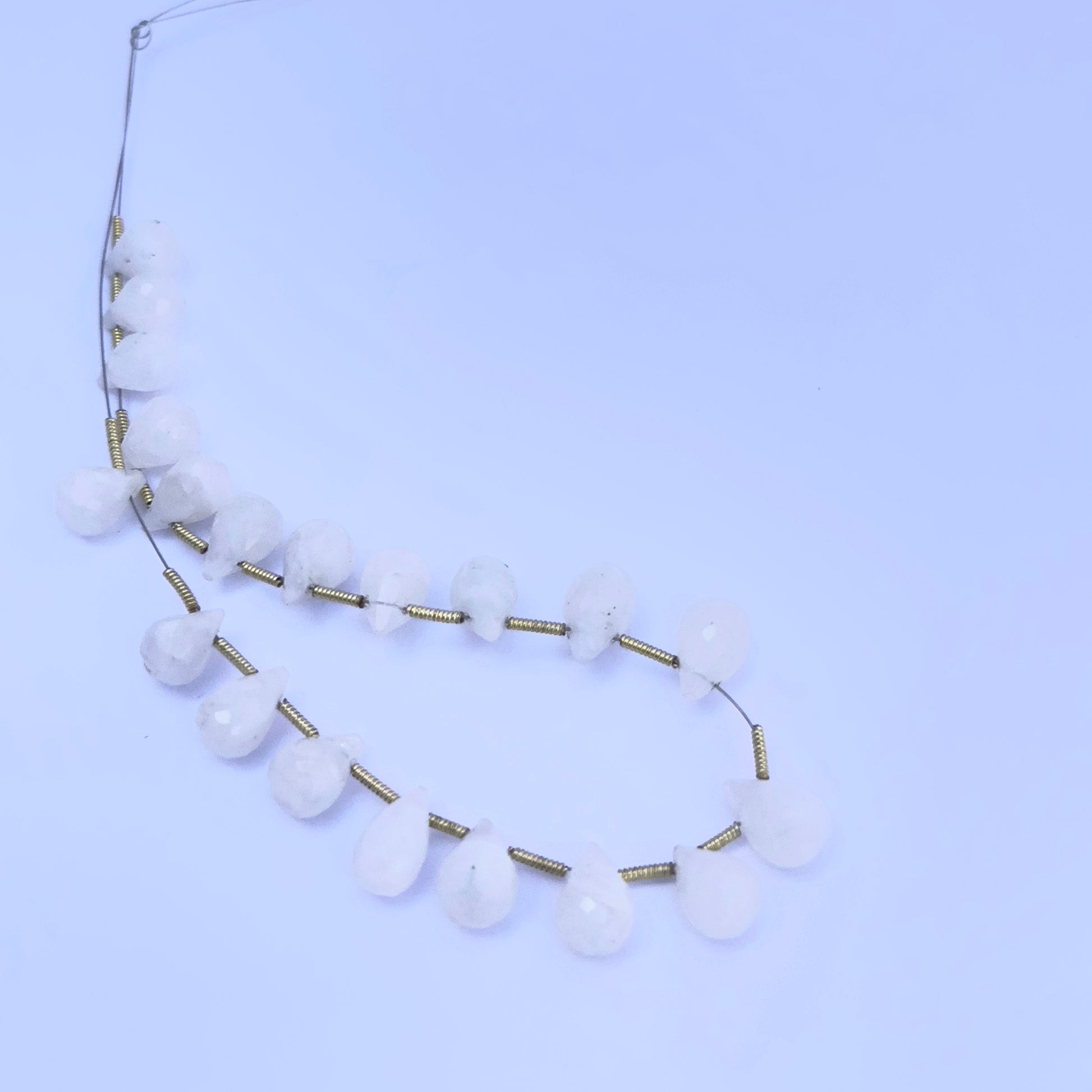 Close-up of shimmering White Rainbow Moonstone beads showing their natural colour play and clarity.