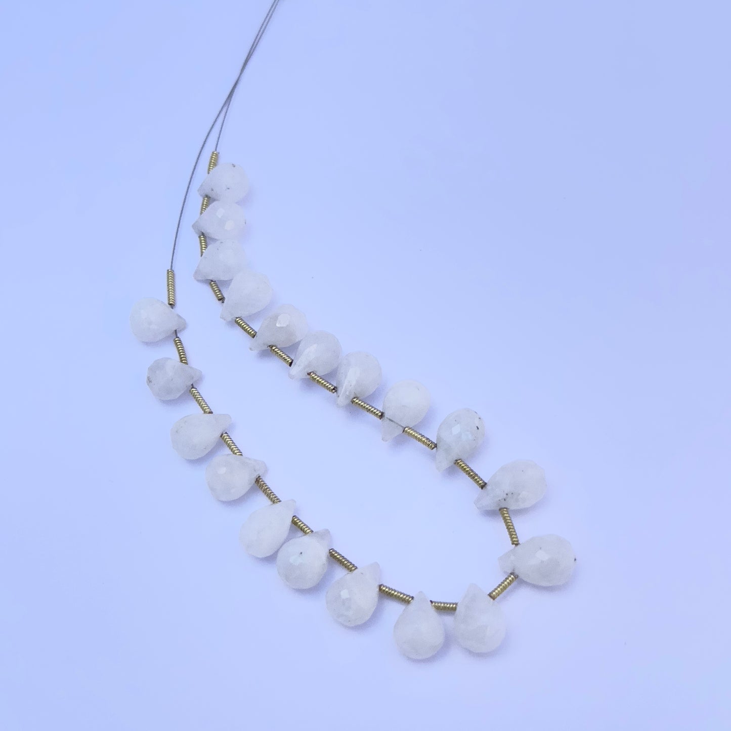 White Rainbow Moonstone gemstone beads laid out for DIY jewellery making and design inspiration.
