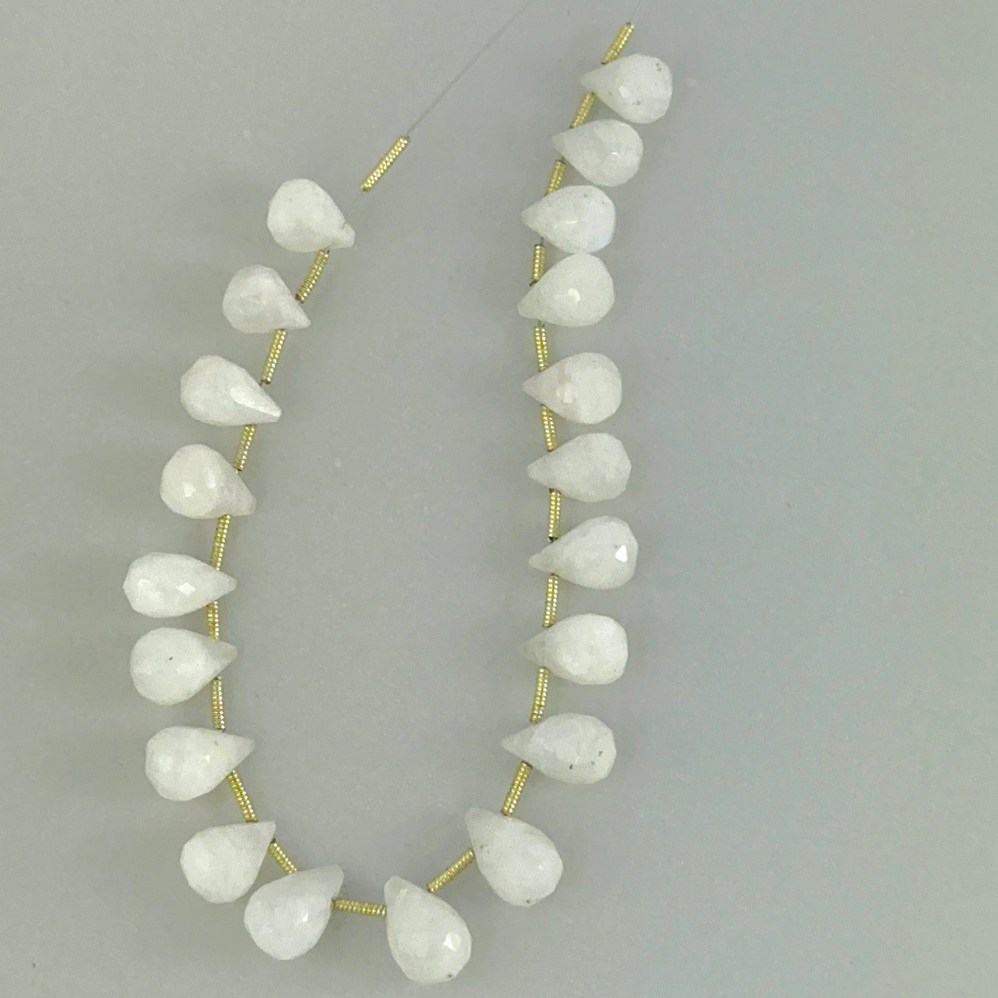 White Rainbow Moonstone faceted teardrop beads showing soft glow and clean gemstone cuts.