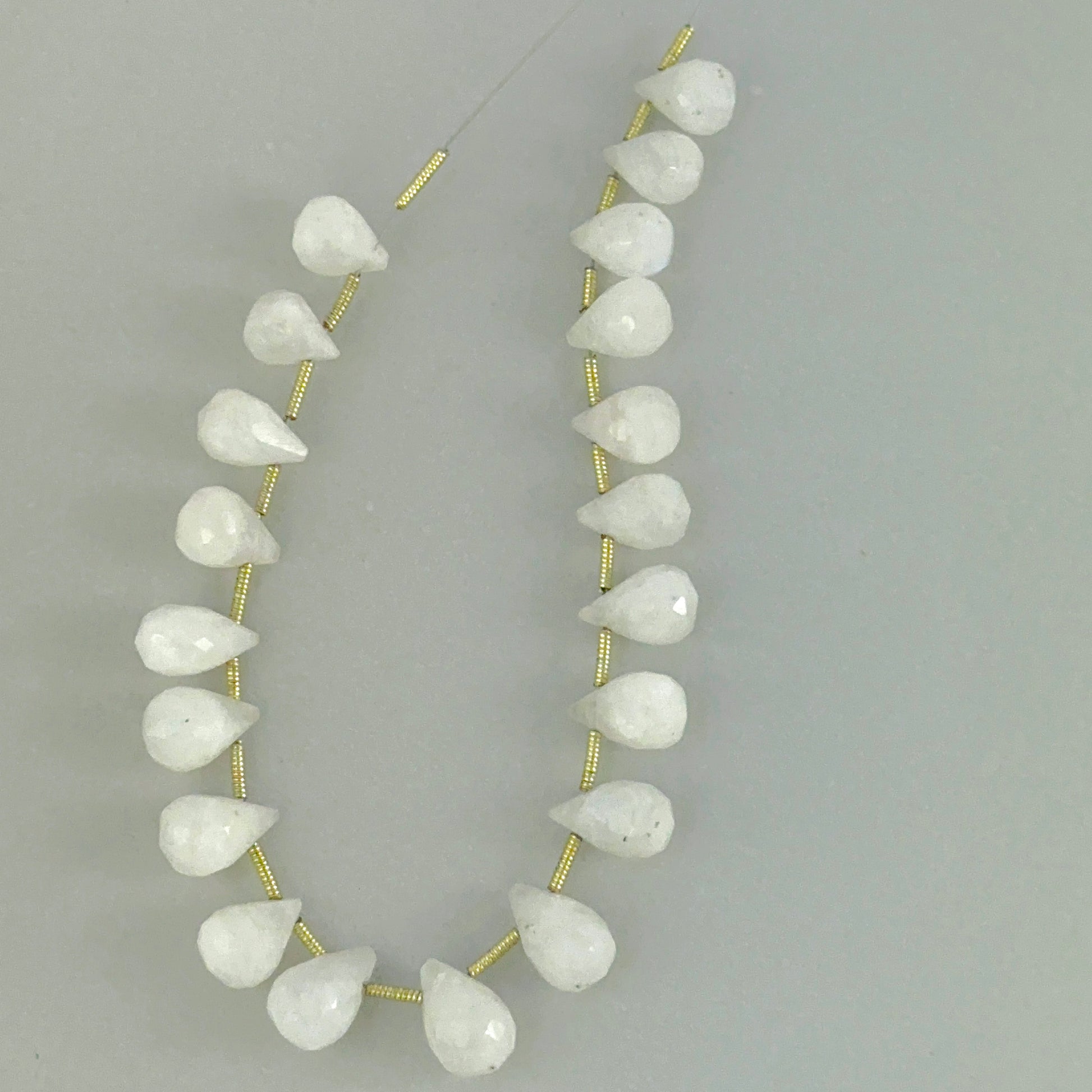 White Rainbow Moonstone faceted teardrop beads showing soft glow and clean gemstone cuts.