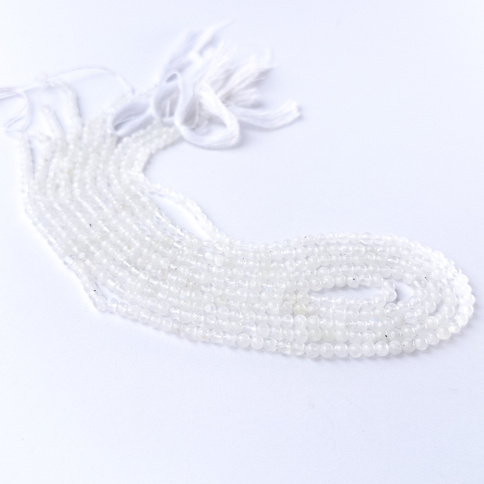 Genuine White Rainbow Moonstone stone beads for DIY jewellery featuring polished round shaping and luminous colour.