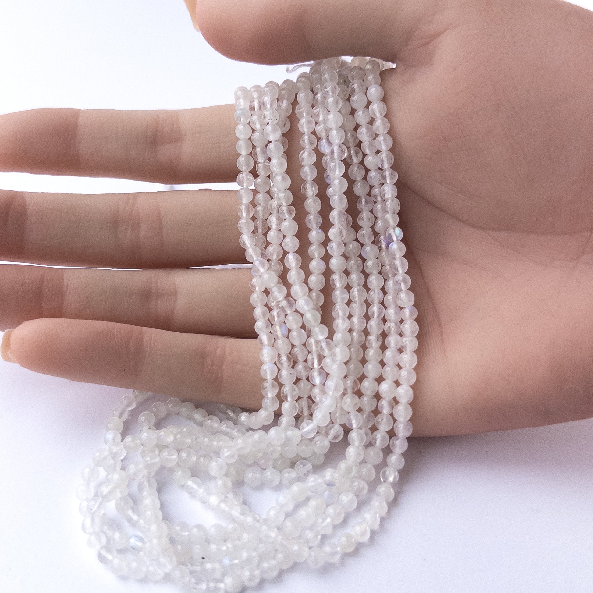 Premium Moonstone smooth round beads arranged neatly on a long strand with delicate 3.5mm sizing.