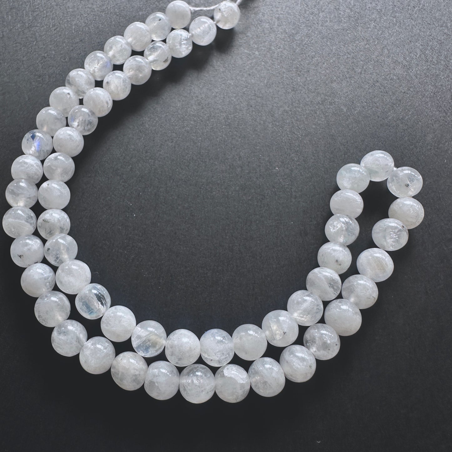 32cm strand of White Rainbow Moonstone gemstone rounds arranged for DIY jewellery inspiration.