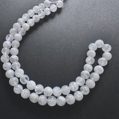 32cm strand of White Rainbow Moonstone gemstone rounds arranged for DIY jewellery inspiration.