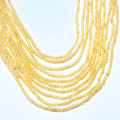 Close‑up of 2.2mm faceted yellow chalcedony beads arranged on a strand.