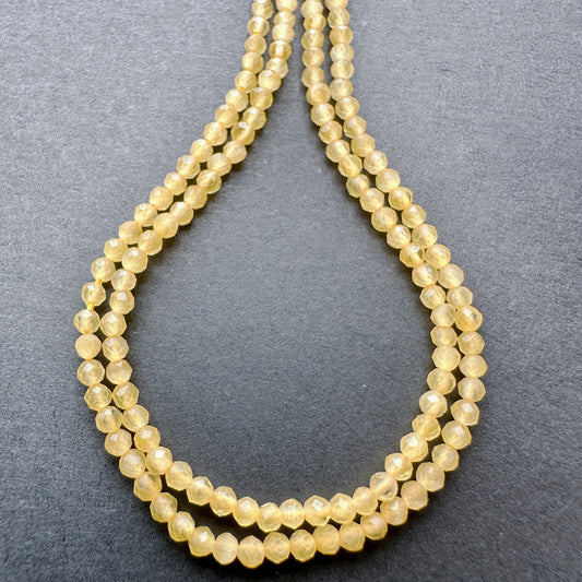 Yellow Chalcedony faceted rondelle beads with warm golden tones arranged on a 35cm strand for jewellery making.