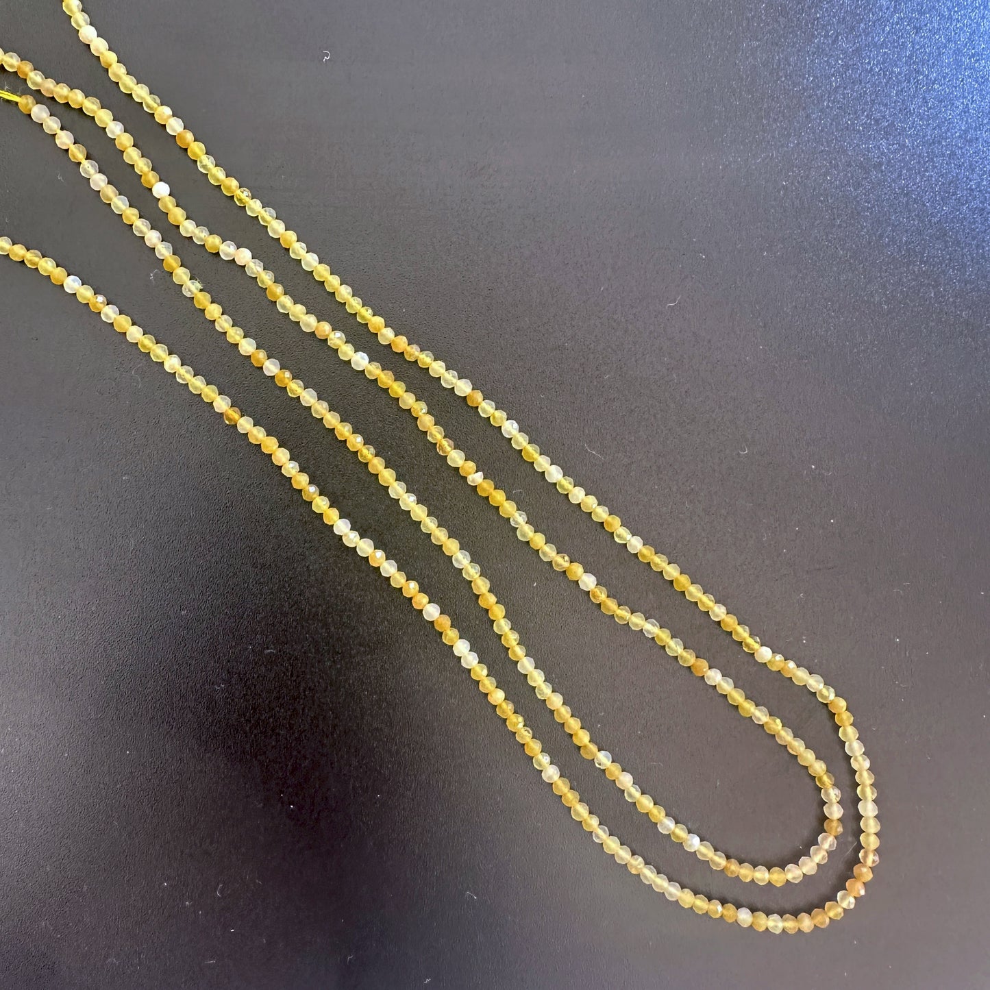 Yellow opal rondelle beads with micro faceting reflect light beautifully in a soft, golden glow.