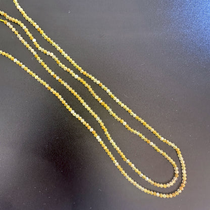 Yellow opal rondelle beads with micro faceting reflect light beautifully in a soft, golden glow.