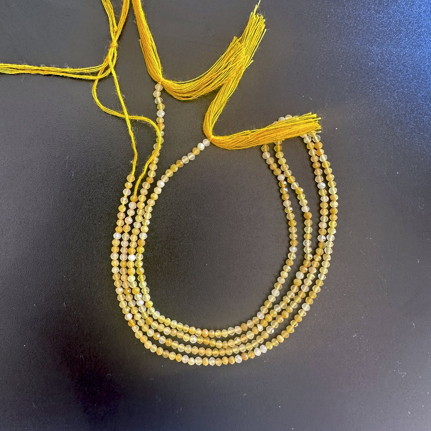 Close-up of yellow opal rondelle beads showing delicate faceting and warm golden tones.