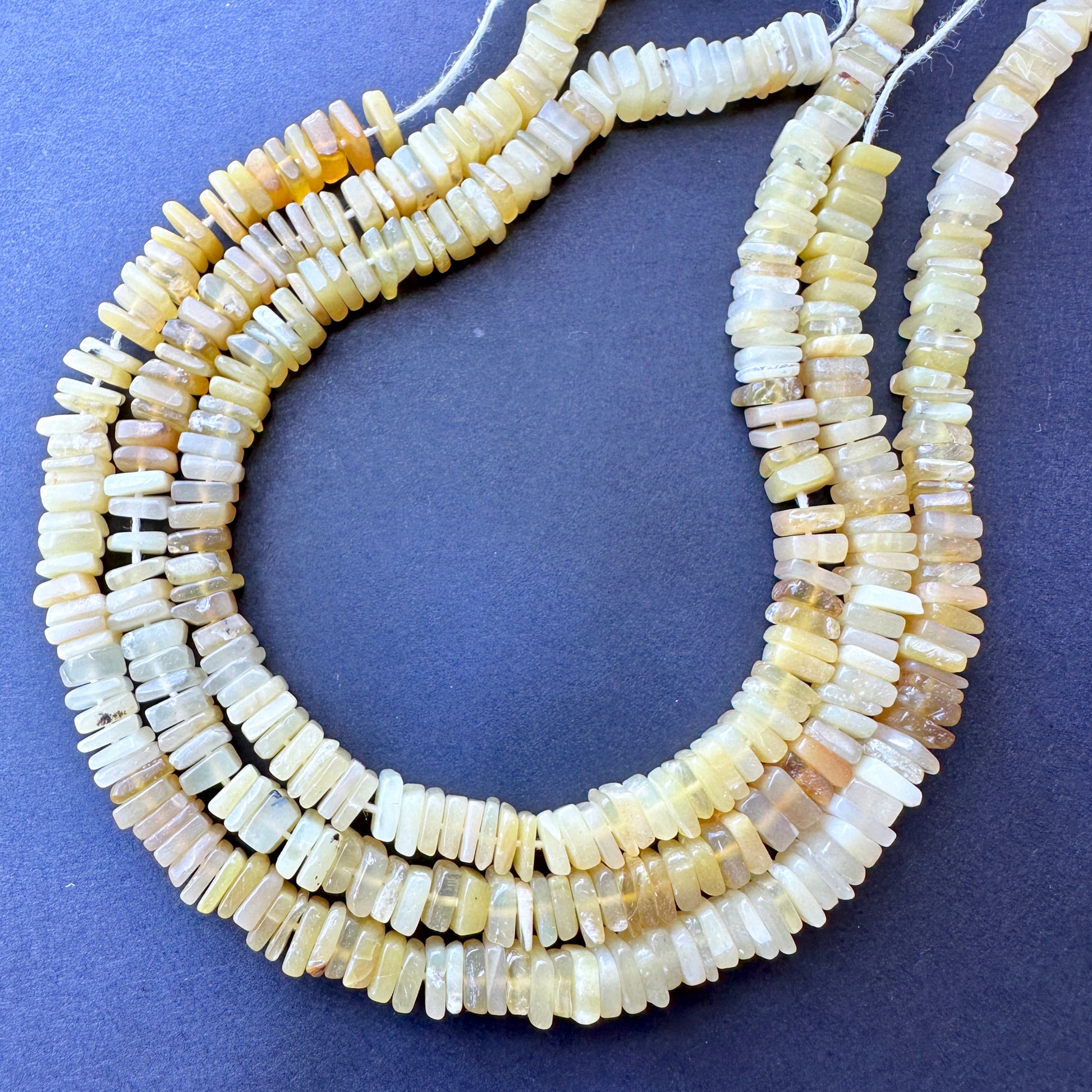 Yellow opal square beads in 5-5.5mm size arranged on a 20cm strand with glossy finish and natural gemstone bead quality