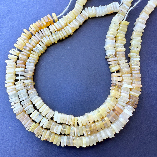 Yellow opal square beads in 5-5.5mm size arranged on a 20cm strand with glossy finish and natural gemstone bead quality