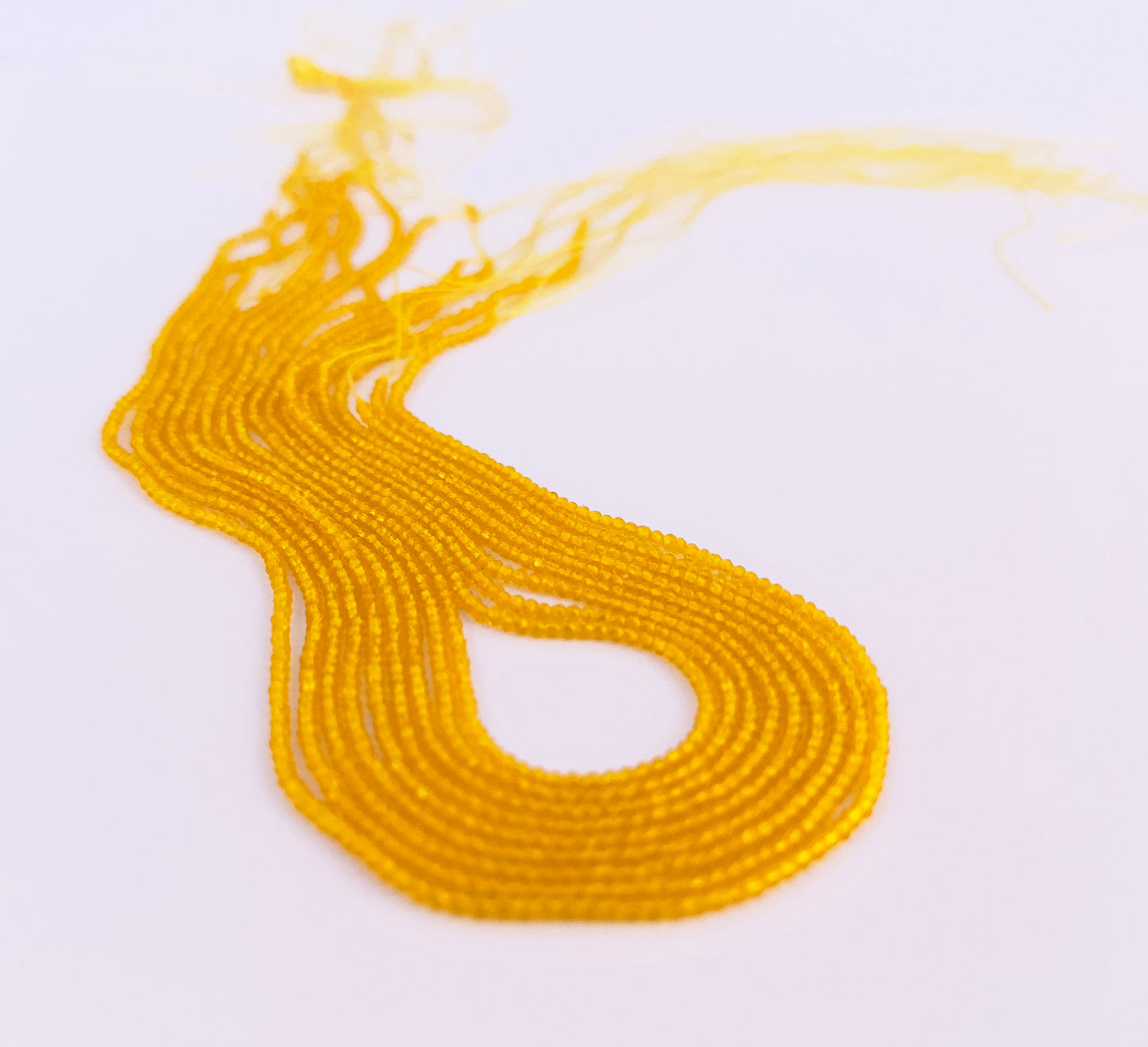 Natural Yellow Quartz stone beads arranged in strands with warm golden shimmer.