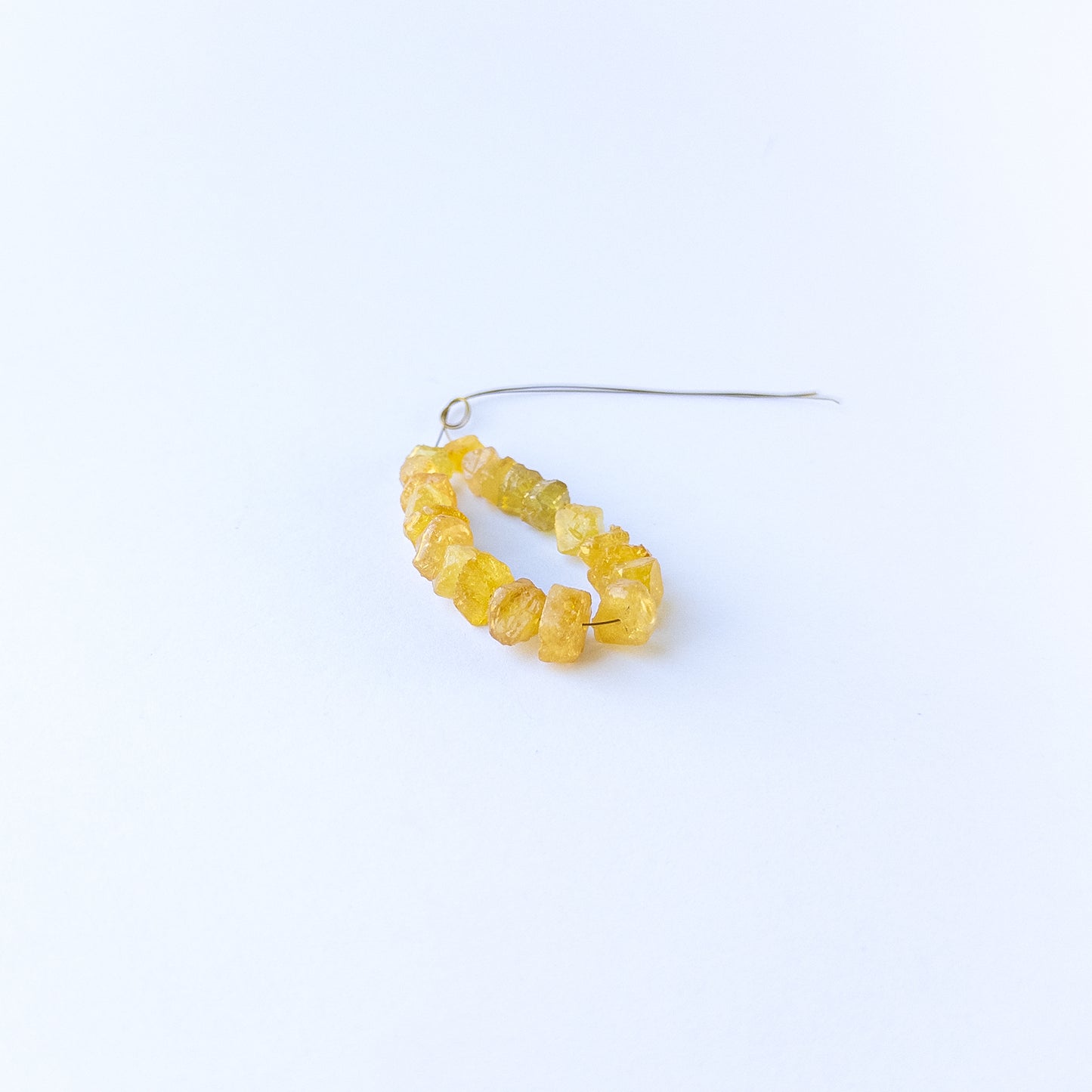 Handmade jewellery components with natural yellow sapphire drilled rough beads arranged in a 20‑piece set.
