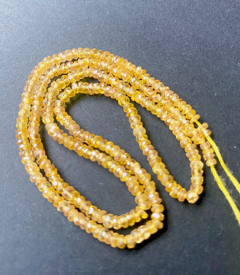 Glowing Yellow Sapphire rondelles with high-quality finish and consistent cut presented on display.