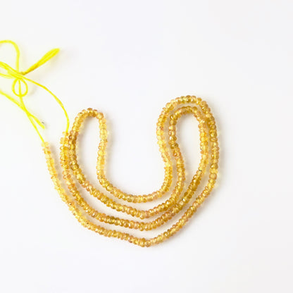 Yellow Sapphire rondelle beads with natural golden hues and reflective faceting, ideal for authentic gemstone beads in creative jewellery designs.