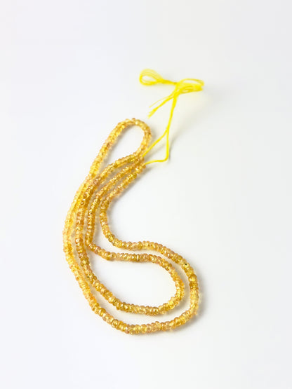 Yellow Sapphire faceted rondelle beads in a long strand, displaying warm tones and elegant handcrafted appeal.