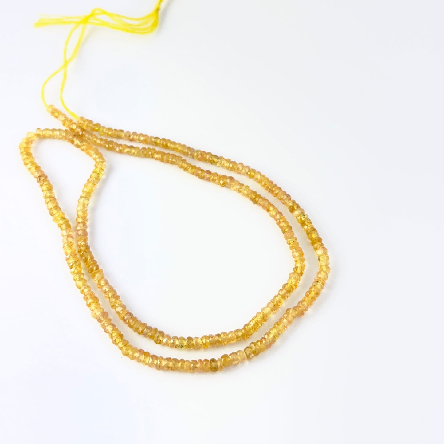 Yellow Sapphire faceted rondelle gemstone beads showing bright golden tones and sparkle for DIY jewellery makers.